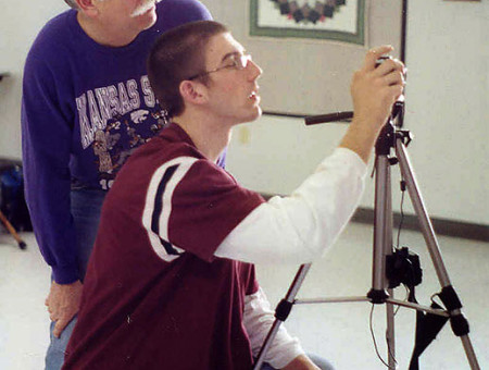 Volunteer Bob Harlan helps a Kansas 4-H member line up a photo.