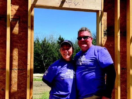 Lisa Pfannenstiel-Garrison and Jim Garrison share a special message with campers who will stay in the cabin their family named within the Stoneybrook community. At the Camp Beautification Day in April, they had the chance to sign the beams in their cabin.